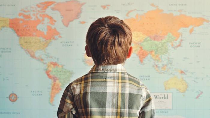 Little boy looking at world map