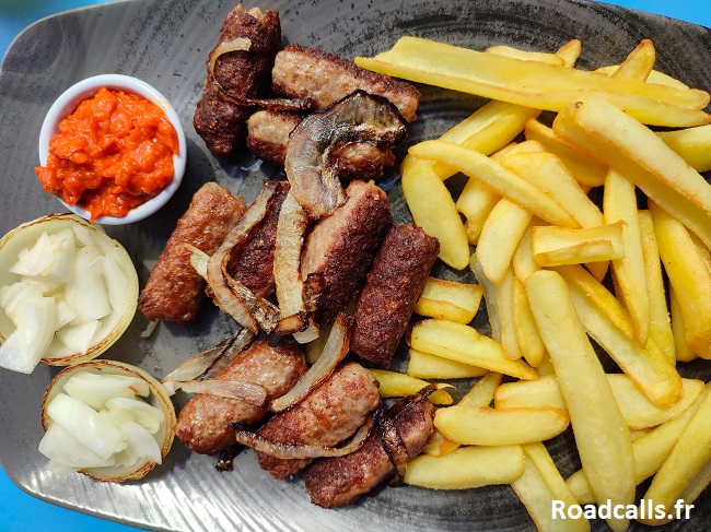 Plat de cevapi accompagnés de frites et d'ajvar.