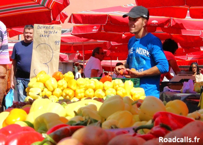 Un vendeur souriant à son stand sur le marché Dolac de Zagreb