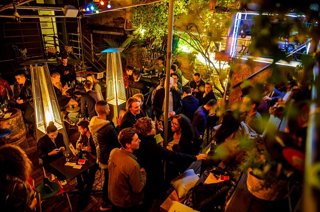 Vue plongeante sur la terrasse très animée du Swanky, de nuit.