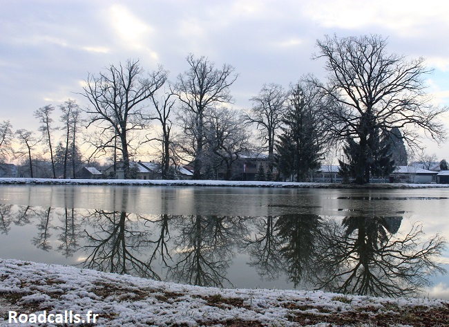 Petit lac gelé, en hiver, à côté de Zagreb, bordé de grands arbres ayant perdus leurs feuilles.