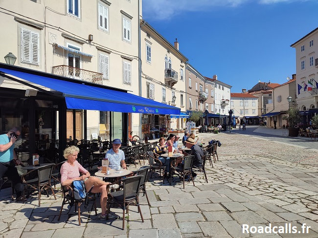 Quelques couples qui se détendent à la terrasse d'un café, le Rialto, sur une place pavée de l'île de Cres, en Croatie.
