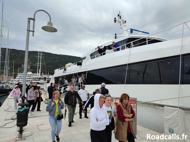 Des voyageurs débarquent du ferry sur le ponton de l'île de Cres, en Croatie, par temps maussade.