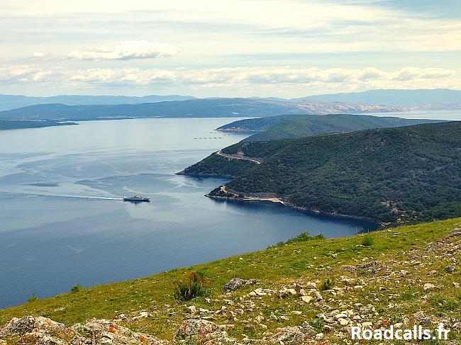 Vue depuis le sommet de l'île de Cres : un ferry se dirige vers la côte dans le bras de mer.